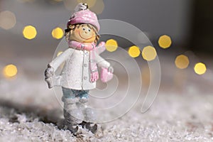 Decorative Christmas-themed figurines. Statuette of a man on skates. Christmas tree decoration. Festive decor, warm bokeh lights