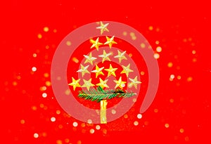 Decorative christmas tree of golden stars on red background. Creative pattern. Close-up