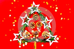 Decorative christmas tree of golden stars on red background. Creative pattern. Close-up