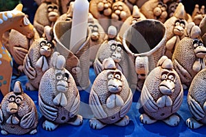 Decorative clay roosters stand on a counter at a Christmas market