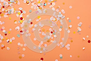 Decorative and colorful confetti on orange background.