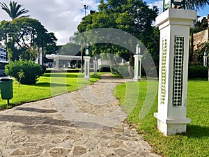 Decorative columns and a path between grass and greenery in the public park