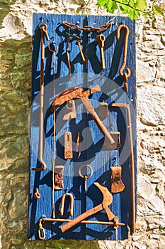 Decorative composition of working tools on the house wall. Lania. Cyprus