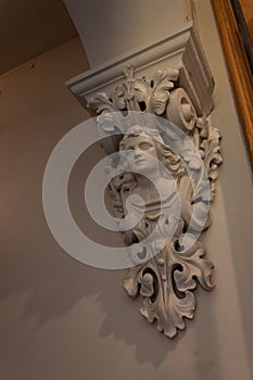 Decorative corbel in a house with bust of a woman, painted cast plaster