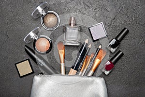 Decorative cosmetics and cosmetic bag on a black background.