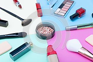 Decorative cosmetics, makeup products and brushes on pastel color background