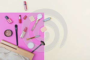 Decorative cosmetics, makeup products and brushes on pink background