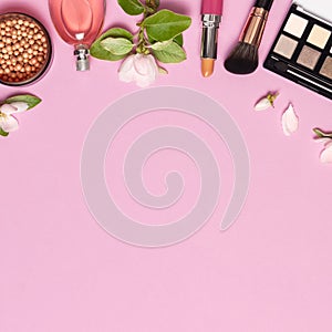 Decorative cosmetics mascara powder lipstick eyeshadow blush balls makeup brush perfume blooming spring branches on pink