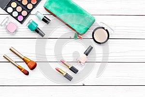 Decorative cosmetics set with brushes, lipstick, eyeshadow and nail polish on white desk background top view copy space