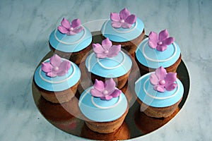 Decorative cupcakes with blue lids and crimson flowers