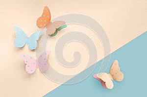 Decorative cute colorful paper butterflies. Top view, copy space for your text on blue and beige background. Beautiful desigh for