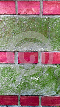 Decorative design on the facade of the house with red brick and green plaster. Texture background