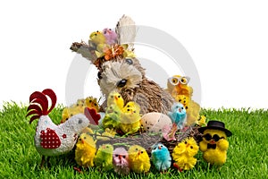 Decorative easter chickens, easter bunny in nest and hen on plastic grass, isolated on white background