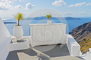 Decorative elements adorn traditional Greek house. Therasia on backdrop. Santorini ( Thira ) island