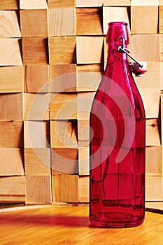 Decorative faceted medieval bottle of wine on a traditional winery table.