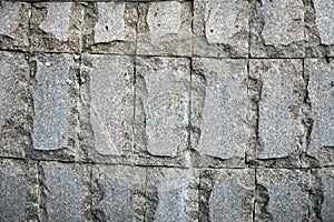 Decorative facing, made of a scabrous gray granite plates with a natural ornament.