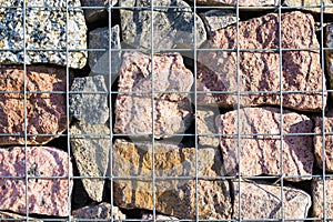 Decorative fence made from rocks behind wires