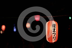 Decorative festival lanterns hung in Wakayama castle park for night viewing of Sakura
