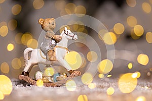 Decorative figurines of a Christmas theme. Figurine of a little teddy bear on a rocking horse. Christmas tree decoration. Festive