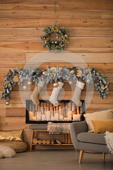 Decorative fireplace with Christmas stockings in room interior