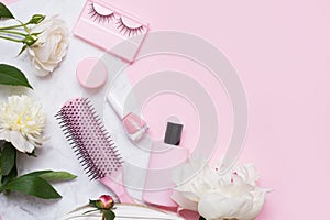 Decorative flat lay composition with cosmetics and flowers. Flat lay, top view on pink background
