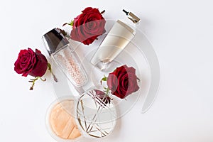 Decorative flat lay composition with cosmetics and flowers. Flat lay, top view on white background with copy space