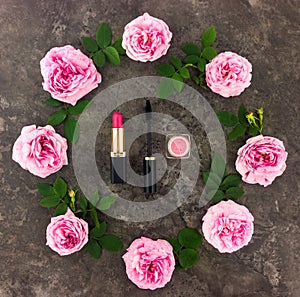 Decorative flat lay composition with cosmetics and flowers. Top view