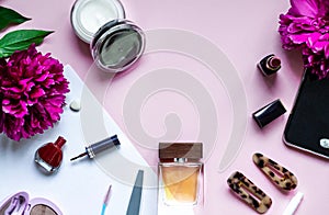 Decorative flat lay composition with cosmetics and flowers. Top view on white and pink background with place for your text