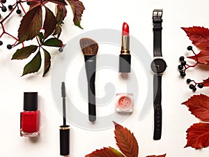 Decorative flat lay composition with cosmetics, woman accessories and autumn leaves and berries. Flat lay, top view