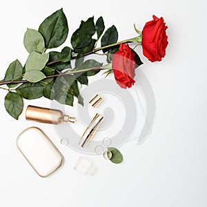 Decorative flat lay composition with cosmetics, women's accessories and flowers. Flat lay, top view on white