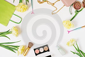 Decorative flat lay composition fashion blogger with makeup products, cosmetics and flowers. Flat lay, top view on white