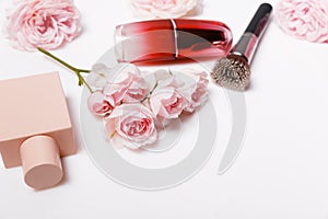 Decorative flat lay composition with makeup products, cosmetics and flowers. Flat lay, top view on pink background