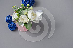 Decorative flowers in a bucket and blue balls on a gray background photo