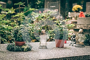 All Saints day, white burning candles and flowers on the grave