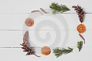 Decorative frame from pine cones, orange slices, cotton and fir branches