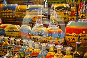 Decorative glass bottles with colored sand inside making shapes of desert and camels