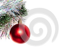 Decorative glass red ball ornament and white tinsel on Christmas tree. Tinsel and tree are blurred. Isolated on white background.
