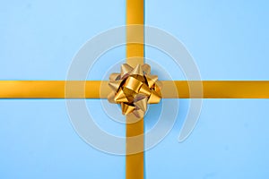 Decorative gold ribbon with a bow over blue