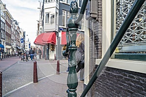 Decorative handrail in the streets of Amsterdam with blurry red venetians in the background photo