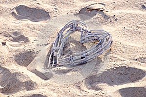 Decorative heart made of reed in beach sand