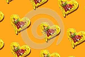 Decorative hearts formed of spaghetti on orange