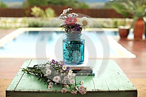 decorative image with flowers, in the external area of a house with a swimming pool