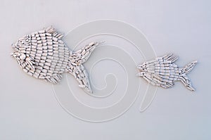 Decorative inlaid fishes on a white wall
