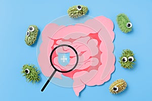 Decorative intestine and magnifying glass. The concept of probiotics and prebiotics for the microbiome and protection intestine