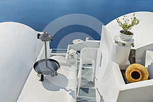 Decorative items adorn the roofs of traditional Greek houses and romantic staircase, leading to the Mediterranean sea. Santorini
