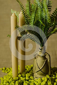 Decorative lamp with ferns and green stone and two candles top view.