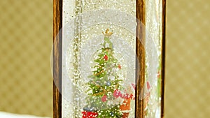 a decorative lantern with a Christmas tree, a bear in a Santa Claus costume