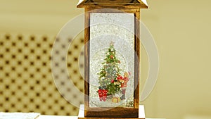 a decorative lantern with a Christmas tree, a bear in a Santa Claus costume