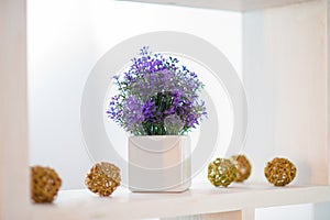 Decorative lavender in a white flowerpot on the shelf