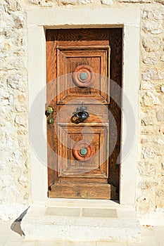 Decorative massive wooden vintage door with smithcrafted decorative doorknocker on church in Razanac